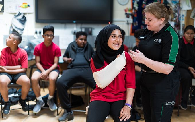 First aid trainer teaching school student