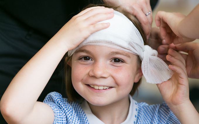School child with bandage around head School child with bandage around head