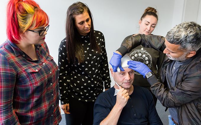 Man practicing applying a head bandage