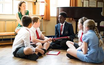 Teacher and students sitting in a group learning first aid