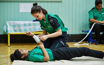 Cadets practising arm bandaging Cadets practising arm bandaging