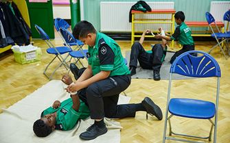 Cadets practising arm bandaging Cadets practising arm bandaging