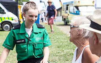 First aider attending elderly couple at outdoor event
